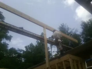 Carpenter setting a ridge beam over a new addition frame — Ice Dam Removal by Roofing Brothers in Angels Camp