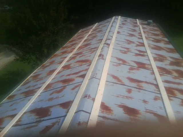 Rusted metal roof panels with new wood purlins before replacement — Storm Damage Roof Repair in Angels Camp by Roofing Brothers