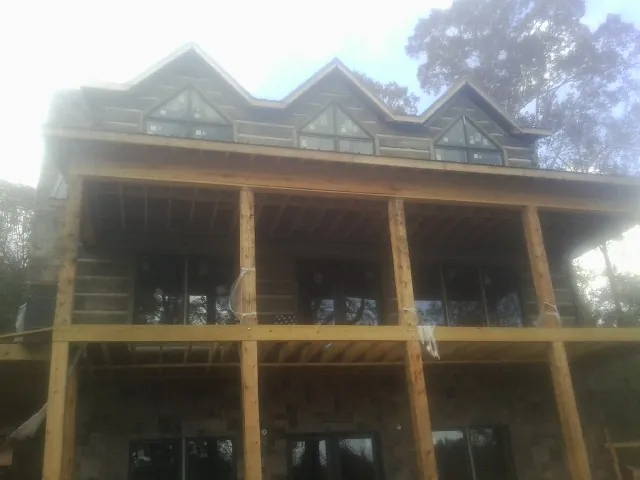 Dormers and porch framing on a large log home under construction — Roof Coating work by our crew in Angels Camp