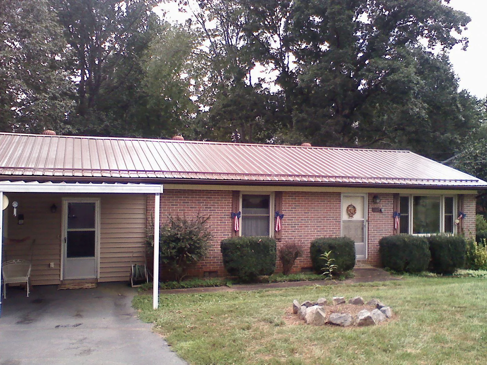 Bronze metal roof and carport on a brick ranch home — Roof Repair work by our crew in Angels Camp